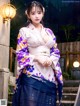 A woman in a purple and blue kimono posing for a picture.