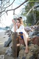 A woman sitting on a rock on the beach.