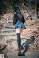 A woman in a school uniform is walking up some steps.