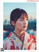 A woman in a kimono poses for a picture.