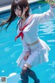 A woman in a sailor outfit standing in a pool.