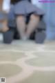 A blurry image of a woman sitting on the floor.