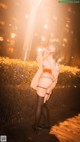 A woman in lingerie posing on a boardwalk at night.